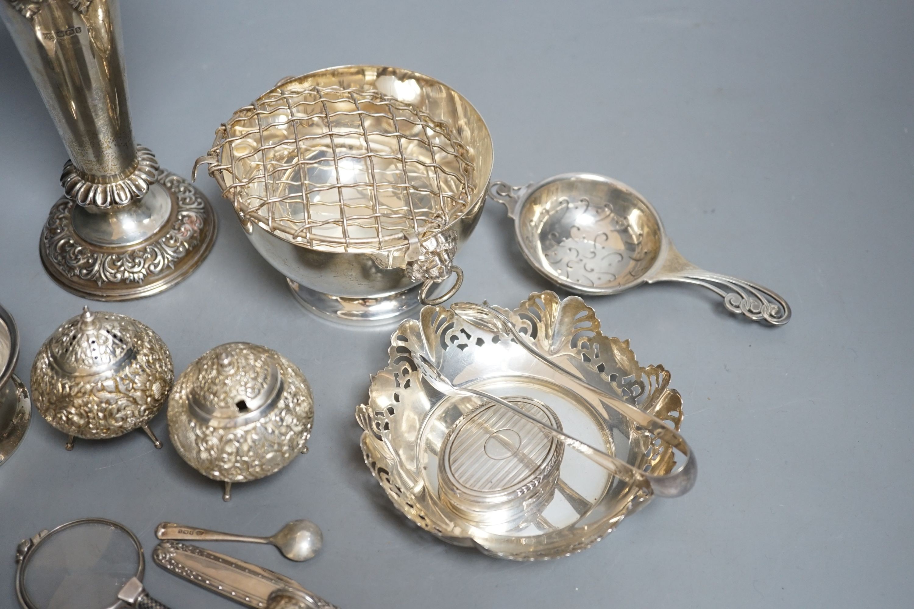 A late Victorian repousse silver vase, Sheffield, 1900, 17.9cm, loaded, a silver tea strainer and stand, a modern silver rose bowl, sterling dish, four condiments including two silver and six other items.